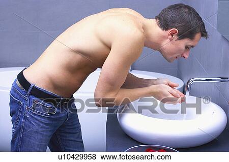 man bending in front of a tap View Large Photo Image Stock Photo - man bending in front of a tap. Fotosearch