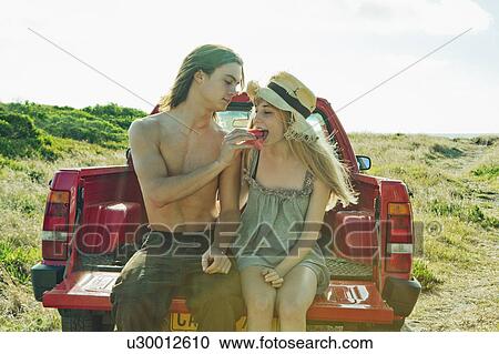 Stock Image - Man feeding young woman watermelon. Fotosearch