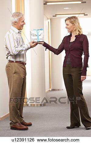 Man getting present from employee View Large Photo Image Stock Photograph - Man getting present from employee. Fotosearch