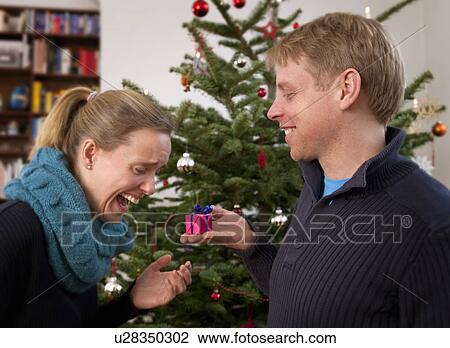 man giving woman small christmas present View Large Photo Image Stock Image - man giving woman small christmas present. Fotosearch