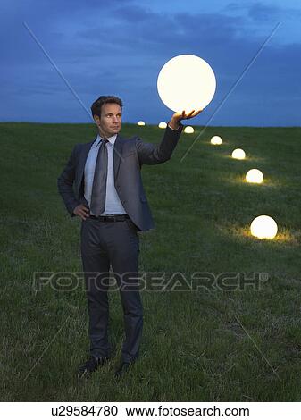 Man holding a lightball View Large Photo Image Stock Image - Man holding a lightball. Fotosearch