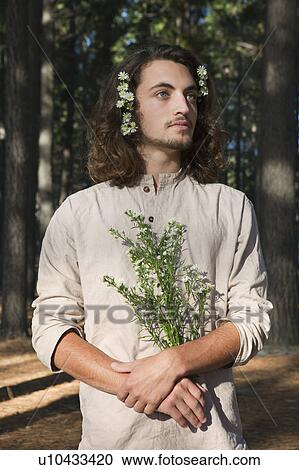 Man holding flowers in forest View Large Photo Image Stock Image - Man holding flowers in forest. Fotosearch