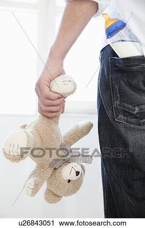 Stock Image - Man holding teddy. Fotosearch