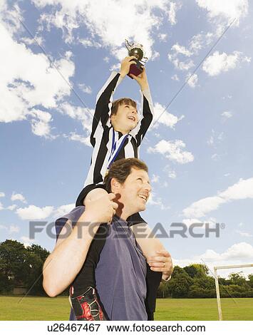 Stock Photo - Man Holding up Boy with Trophy. Fotosearch