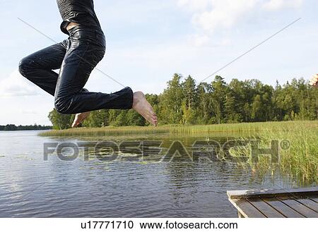 Man jumping in the lake with his clothes View Large Photo Image Stock Image - Man jumping in the lake with his clothes. Fotosearch