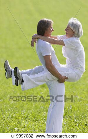 Stock Image - Man lifting wife. Fotosearch