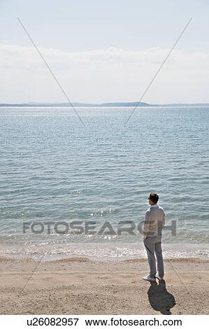 Stock Photo - Man looking at sea. Fotosearch