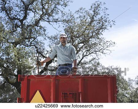 Man on trailer with fork View Large Photo Image Stock Photo - Man on trailer with fork. Fotosearch