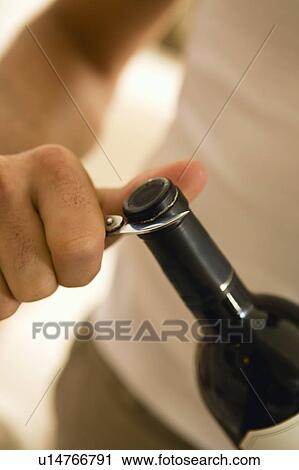 Man opening a bottle of red wine View Large Photo Image Stock Image - Man opening a bottle of red wine. Fotosearch