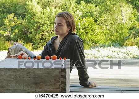 Stock Photography - Man playing with home grown tomatoes. Fotosearch