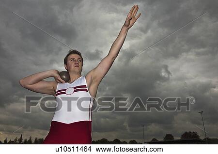 Picture - man putting shot with arm raised. Fotosearch