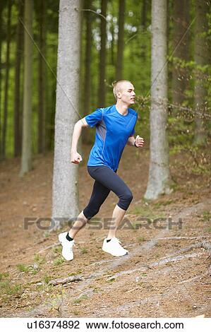 Stock Image - Man running in forest. Fotosearch