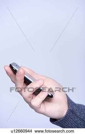 man s hand with a mobile phone View Large Photo Image Picture - man s hand with a mobile phone. Fotosearch