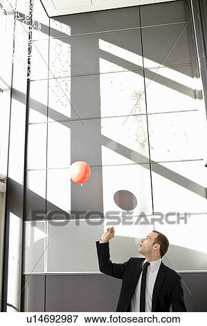 Man setting balloon free in office View Large Photo Image Stock Photo - Man setting balloon free in office. Fotosearch