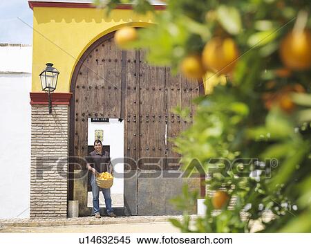Man standing at doorway with oranges View Large Photo Image Stock Photography - Man standing at doorway with oranges. Fotosearch
