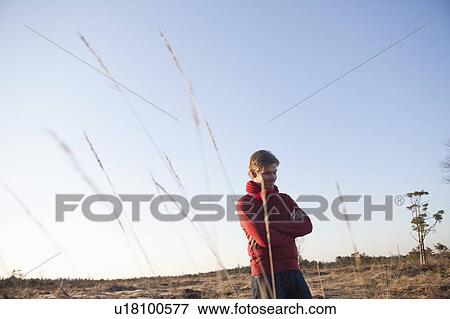 Man standing in open field View Large Photo Image Stock Photo - Man standing in open field. Fotosearch