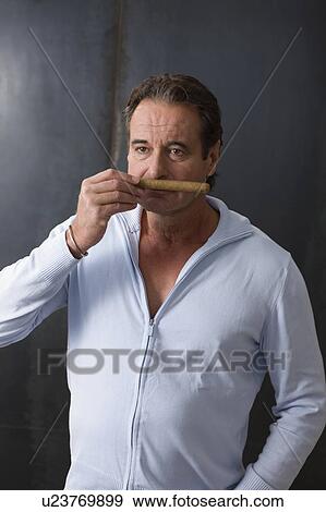 Man taking a smell at a cigar View Large Photo Image Stock Photo - Man taking a smell at a cigar. Fotosearch