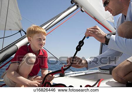 Man teaching boy knot on yacht View Large Photo Image Stock Photograph - Man teaching boy knot on yacht. Fotosearch