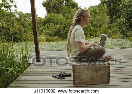 Man using a laptop outdoors View Large Photo Image Stock Image - Man using a laptop outdoors. Fotosearch