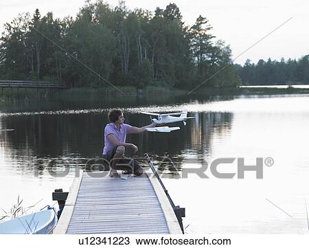 Stock Image - Man with a remote-controlled plane. Fotosearch