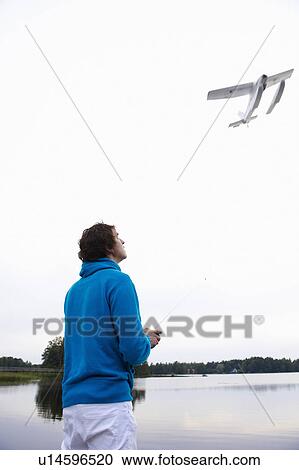 Stock Image - Man with a remote-controlled plane. Fotosearch