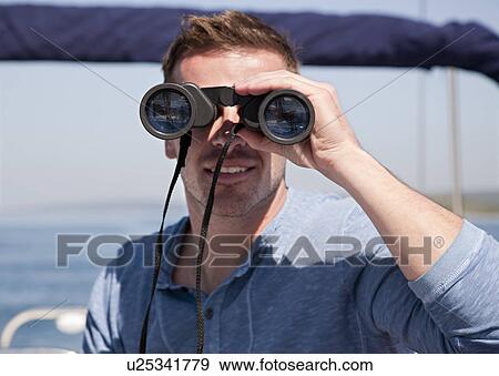 Man with binoculars on yacht View Large Photo Image Stock Photo - Man with binoculars on yacht. Fotosearch