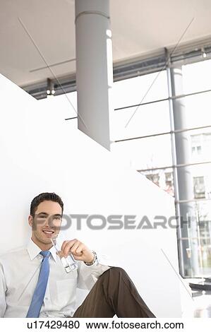 Man with glass of water smiling in break View Large Photo Image Stock Image - Man with glass of water smiling in break. Fotosearch