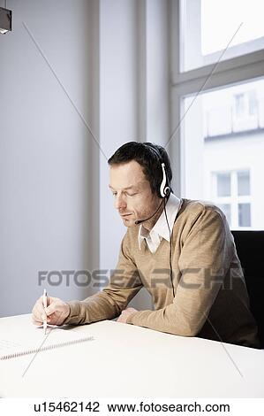 Stock Image - Man with headset in office. Fotosearch