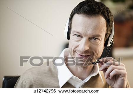Man with headset looking at camera View Large Photo Image Stock Photograph - Man with headset looking at camera. Fotosearch