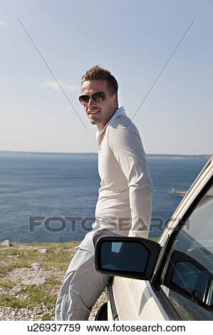 Man with oldtimer overlooking sea View Large Photo Image Stock Photo - Man with oldtimer overlooking sea. Fotosearch