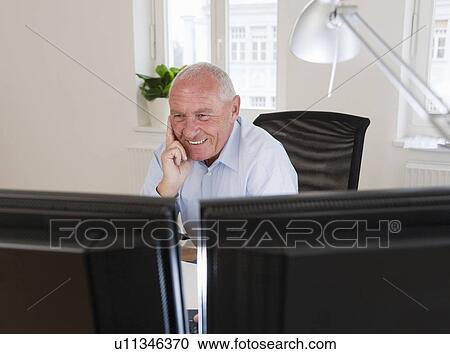 Mature Businessman in front of computer View Large Photo Image Stock Image - Mature Businessman in front of computer. Fotosearch
