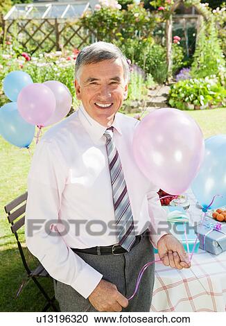 mature man holding balloons. View Large Photo Image Stock Image - mature man holding balloons.. Fotosearch
