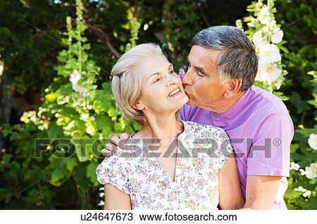 Stock Image - mature man kisses mature woman.. Fotosearch