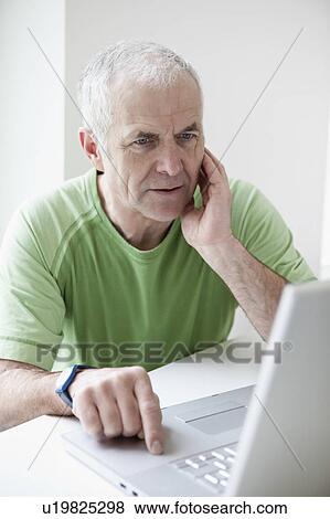 Stock Photo - Mature Man looking at Notebook. Fotosearch