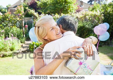 Stock Image - mature woman embracing mature man.. Fotosearch