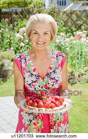 Mature woman holding strawberry tart. View Large Photo Image Stock Image - Mature woman holding strawberry tart.. Fotosearch