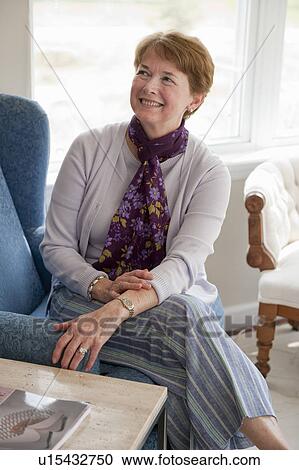 Mature woman smiling in living room View Large Photo Image Stock Image - Mature woman smiling in living room. Fotosearch