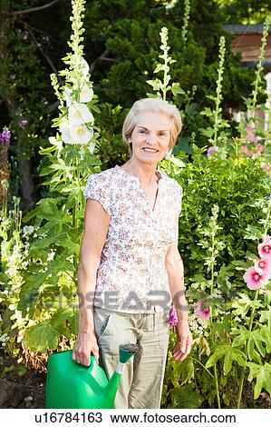mature woman stands in front of flowers. View Large Photo Image Stock Image - mature woman stands in front of flowers.. Fotosearch