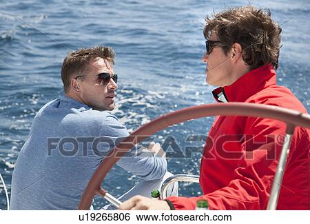 Stock Photograph - Men talking on yacht. Fotosearch