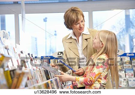 Stock Photograph - Mother and daughter buying DVDs. Fotosearch