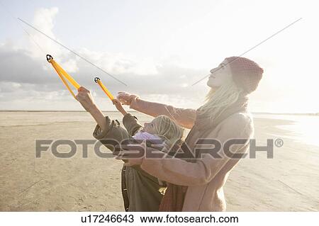 Mother and daughter flying kite on beach View Large Photo Image Stock Image - Mother and daughter flying kite on beach. Fotosearch