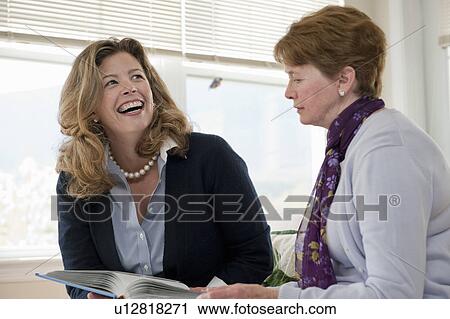 Stock Image - Mother and daughter talking on couch. Fotosearch