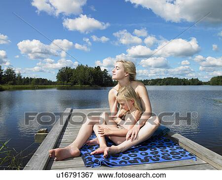 Mother and daughter tanning on a dock View Large Photo Image Stock Photo - Mother and daughter tanning on a dock. Fotosearch
