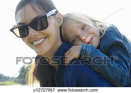 Mother carrying daughter on her back View Large Photo Image Stock Photo - Mother carrying daughter on her back. Fotosearch