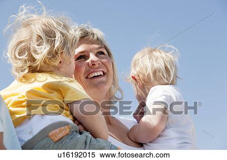 Stock Photography - Mother holding twins. Fotosearch