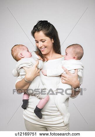 Stock Image - Mother holding two babies. Fotosearch