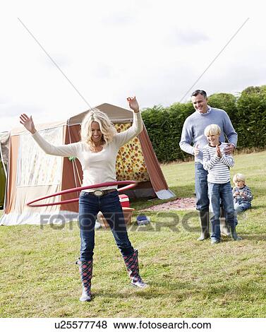 Stock Photo - Mother hula-hooping outdoors. Fotosearch