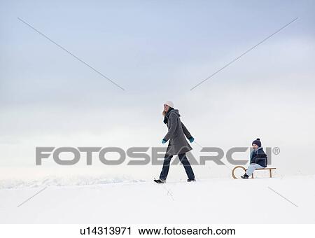 Mother pulling son on sled View Large Photo Image Stock Image - Mother pulling son on sled. Fotosearch