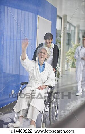 Stock Image - Old woman in a wheel chair and nurse. Fotosearch
