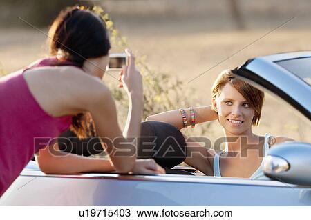 One woman taking a picture of another View Large Photo Image Stock Image - One woman taking a picture of another. Fotosearch